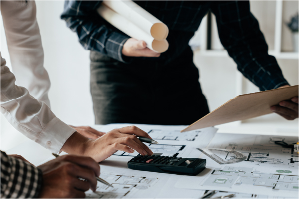 電卓を片手に設計図を囲む人々